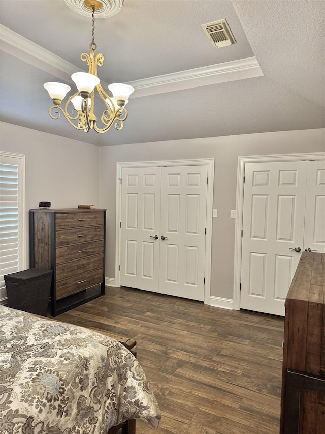 205 N Mayhaw Dr, Vidor, TX 77662 - bedroom with a chandelier, dark wood finished floors, a closet, ornamental molding, and a tray ceiling