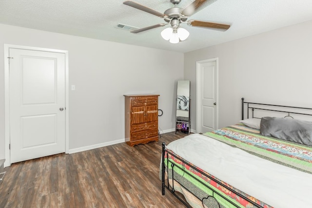 bedroom featuring a textured ceiling, dark hardwood / wood-style floors, and ceiling fan