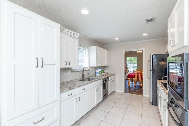 kitchen featuring sink, light stone countertops, a wealth of natural light, appliances with stainless steel finishes, and white cabinetry