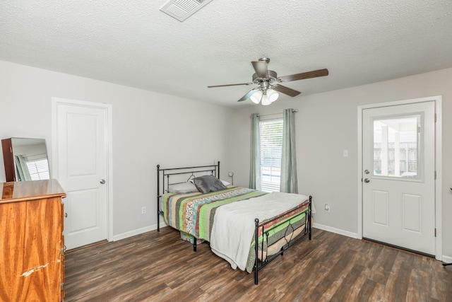 bedroom with ceiling fan, dark hardwood / wood-style floors, and a textured ceiling