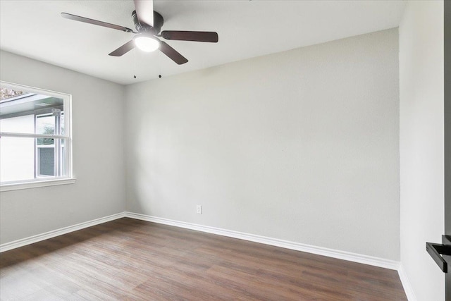 spare room featuring a ceiling fan, baseboards, and wood finished floors