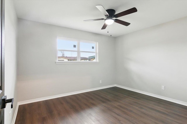 unfurnished room featuring dark wood-style floors, ceiling fan, and baseboards