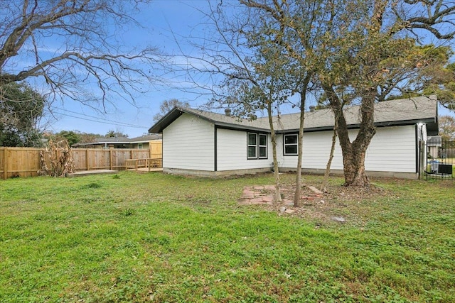 back of property featuring a yard, cooling unit, and fence