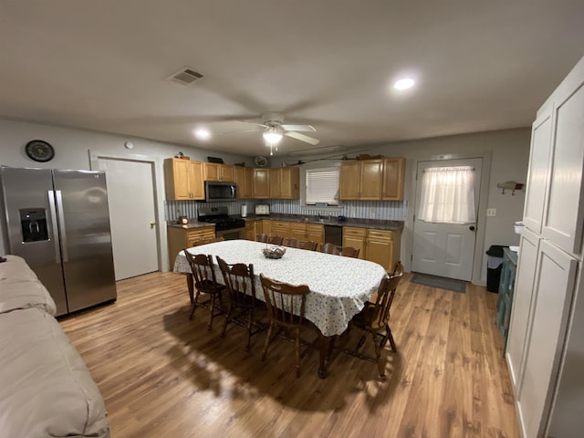 kitchen with tasteful backsplash, ceiling fan, light hardwood / wood-style flooring, and appliances with stainless steel finishes