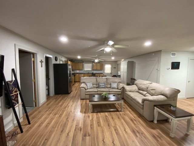 living room with light hardwood / wood-style floors and ceiling fan