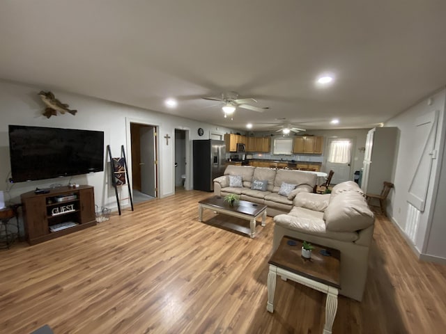 living room featuring ceiling fan and light hardwood / wood-style floors