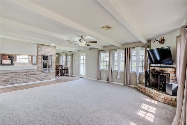 unfurnished living room with beamed ceiling, a fireplace, visible vents, and ceiling fan