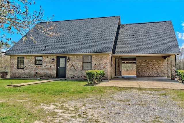 view of front of home featuring a front lawn, a carport, brick siding, and roof with shingles