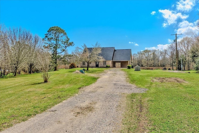 view of front facade with a front yard and dirt driveway