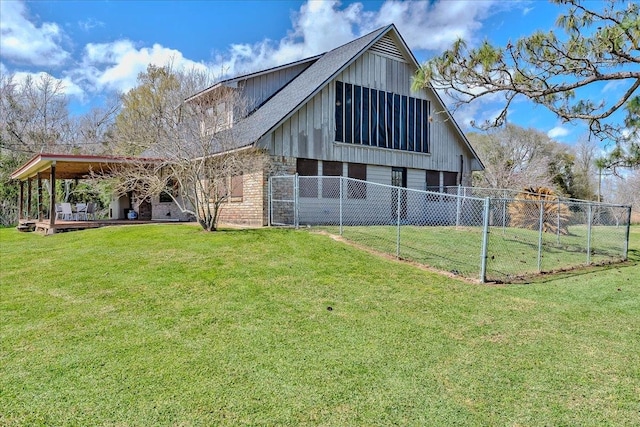 rear view of property featuring an outbuilding, a barn, a yard, and fence