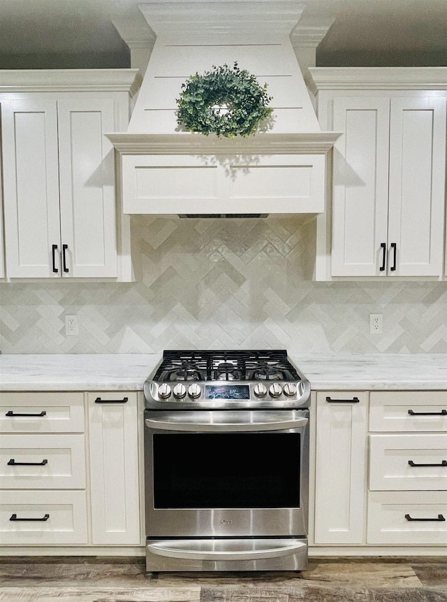 4885 Silver Leaf Dr, Orange, TX 77630 - kitchen with stainless steel range with gas stovetop, custom range hood, backsplash, white cabinetry, and crown molding