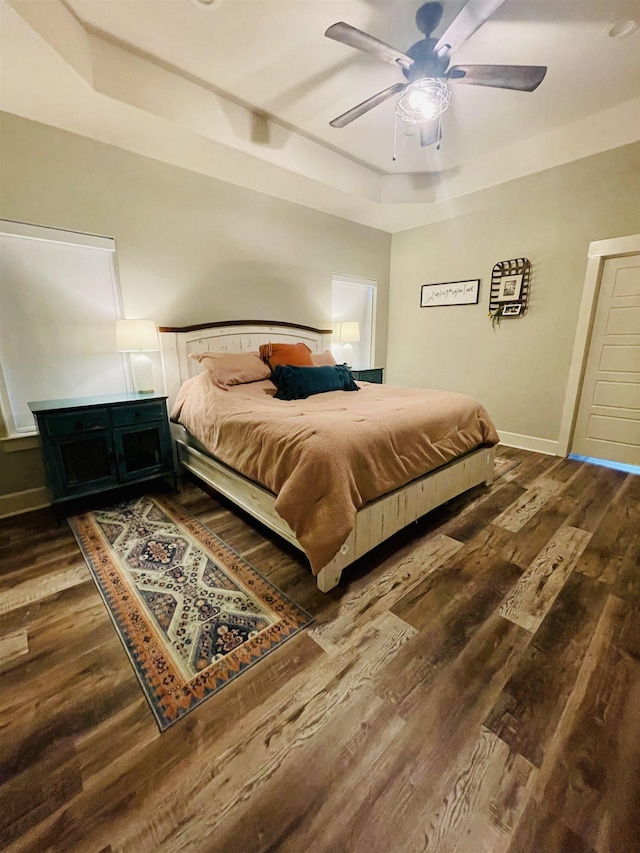 4885 Silver Leaf Dr, Orange, TX 77630 - bedroom featuring a tray ceiling, dark wood-style flooring, and ceiling fan
