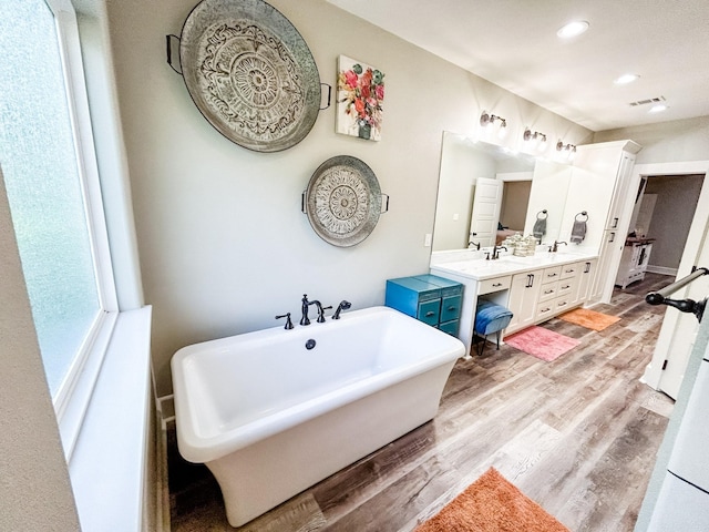 4885 Silver Leaf Dr, Orange, TX 77630 - bathroom with double vanity, a freestanding tub, wood finished floors, and recessed lighting