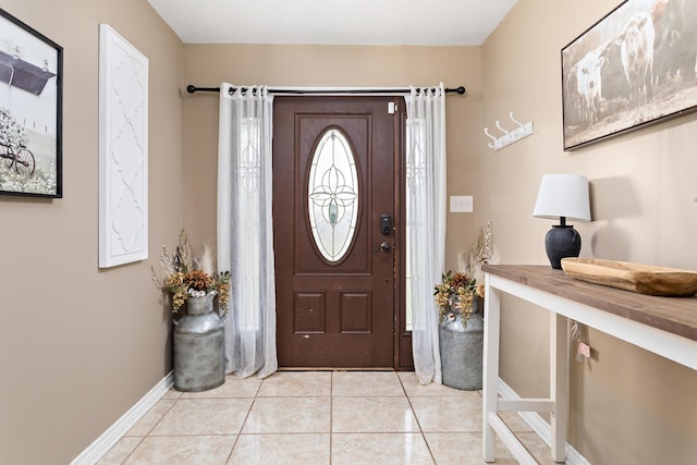 foyer entrance featuring light tile patterned floors and baseboards