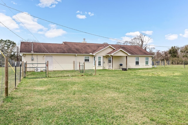 back of property with a gate, a yard, and fence