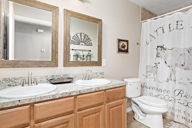 full bathroom with tile patterned flooring, double vanity, toilet, and a sink