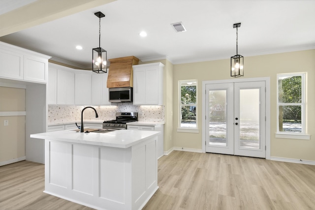 103 Ned, Lumberton, TX 77657 - kitchen with appliances with stainless steel finishes, light wood-style floors, decorative backsplash, light countertops, and white cabinetry