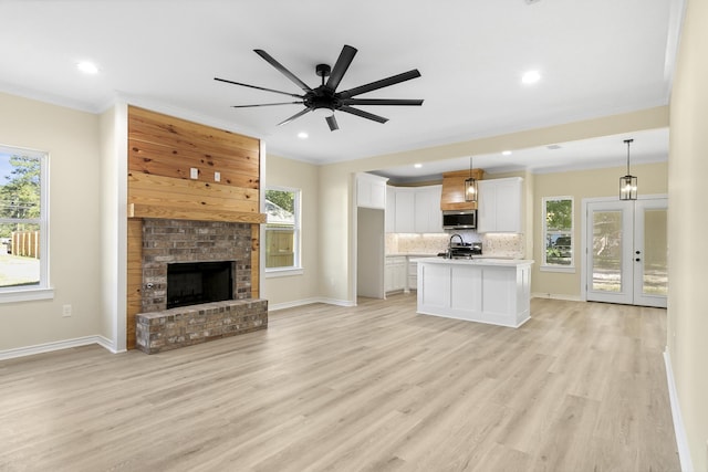103 Ned, Lumberton, TX 77657 - unfurnished living room with ornamental molding, light wood-style floors, recessed lighting, ceiling fan, and a fireplace