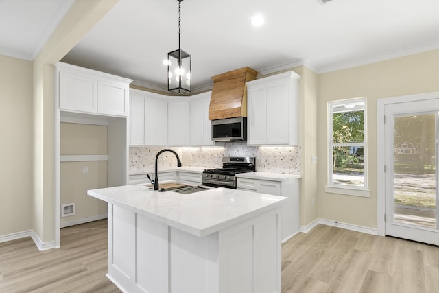 103 Ned, Lumberton, TX 77657 - kitchen with stainless steel appliances, light wood finished floors, tasteful backsplash, white cabinetry, and light countertops