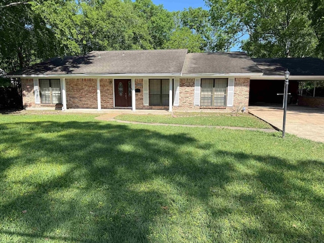 ranch-style home featuring concrete driveway, an attached carport, a front lawn, and brick siding
