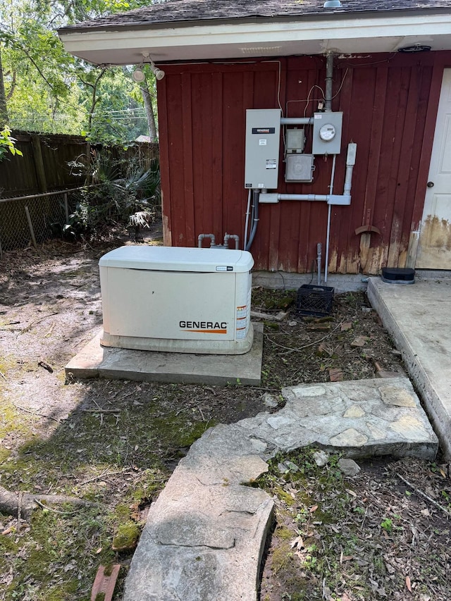 exterior details featuring a shingled roof, fence, a power unit, and electric meter