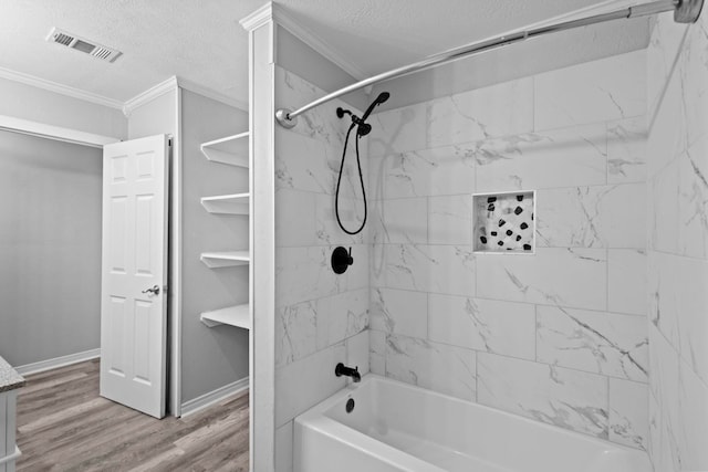 bathroom featuring crown molding, a textured ceiling, shower / bathtub combination, and wood finished floors