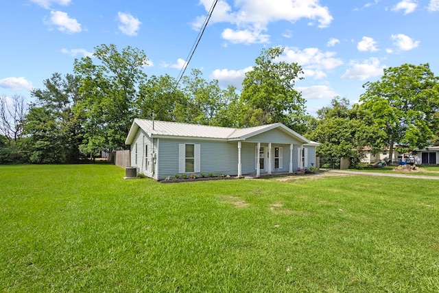 view of home's exterior featuring a lawn, central AC unit, and metal roof