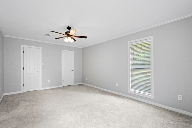 carpeted spare room with ornamental molding, ceiling fan, and baseboards