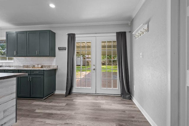 doorway to outside featuring french doors, ornamental molding, plenty of natural light, and light wood finished floors