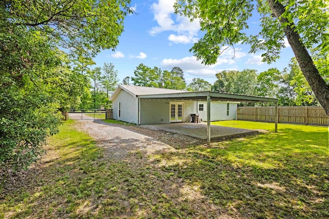 back of property featuring french doors, a patio, metal roof, and a carport