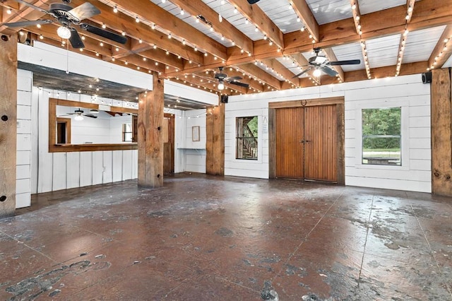 misc room featuring beamed ceiling and wooden walls