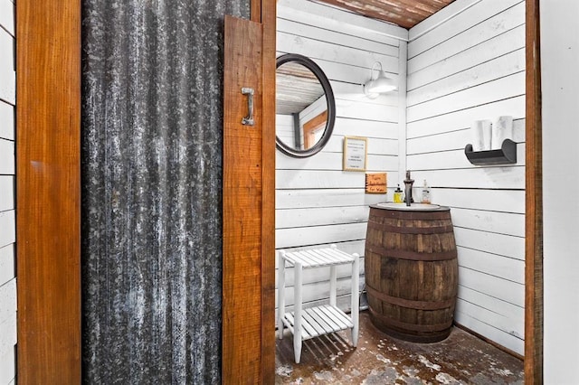 bathroom with wooden walls and wood ceiling