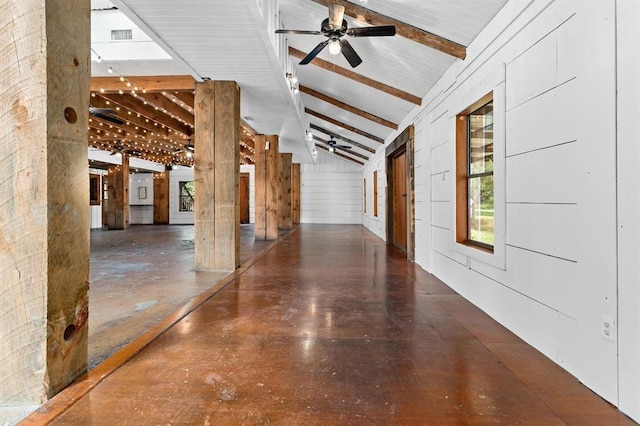 hall with beamed ceiling, high vaulted ceiling, and wood walls