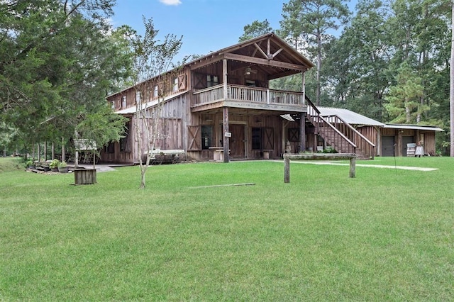 back of property featuring a lawn and ceiling fan