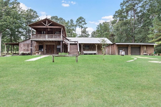 view of front of house featuring a carport, a garage, a front lawn, and an outdoor structure