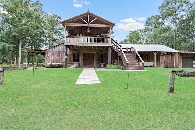 back of house with ceiling fan, an outbuilding, and a yard