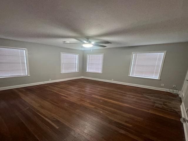 spare room with ceiling fan, dark wood-type flooring, and a textured ceiling