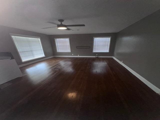 unfurnished living room with ceiling fan and dark hardwood / wood-style floors