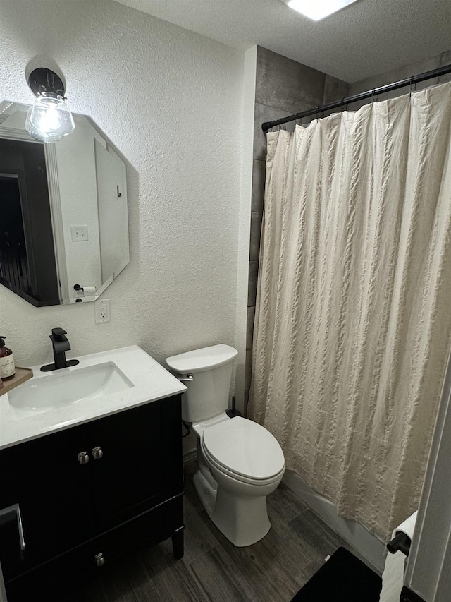 bathroom with walk in shower, a textured ceiling, vanity, hardwood / wood-style flooring, and toilet