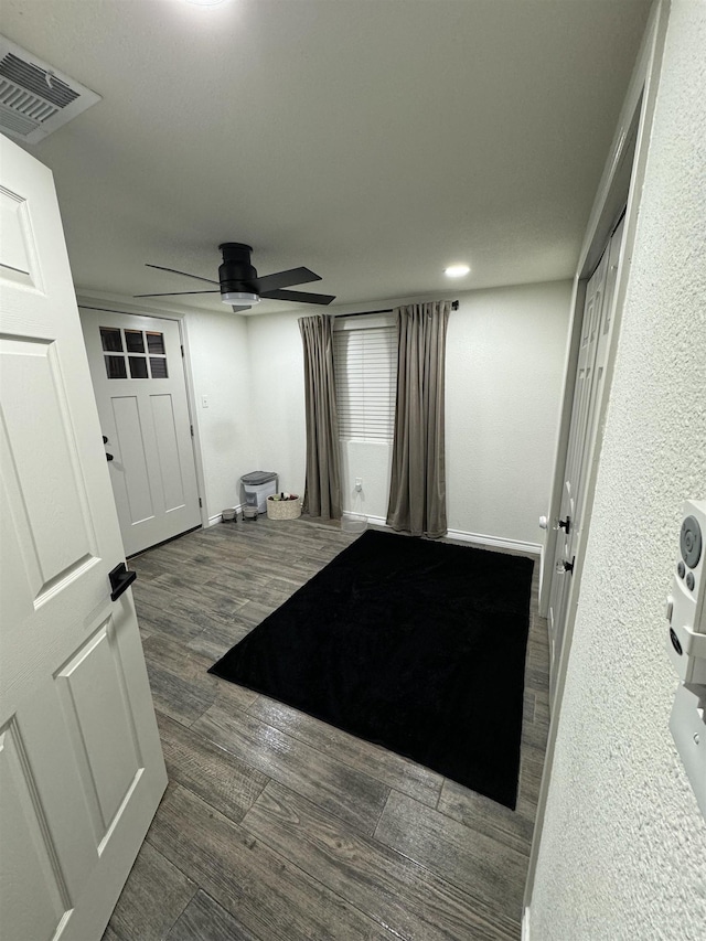 interior space with ceiling fan and dark wood-type flooring