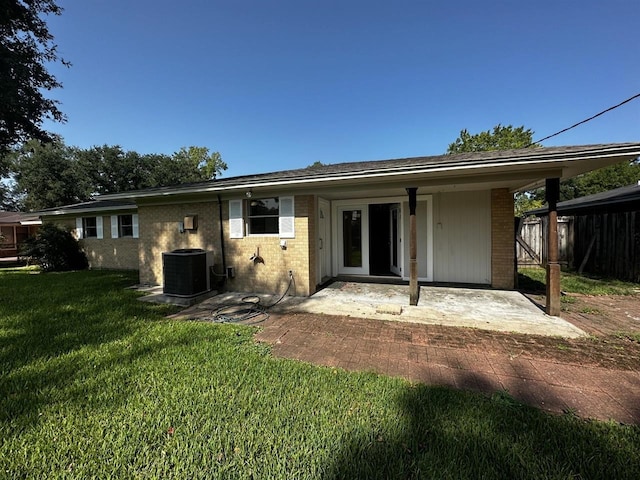 back of property featuring cooling unit, a patio area, and a yard