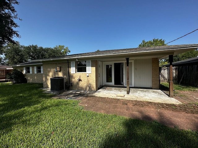 back of property with a patio, central air condition unit, and a lawn