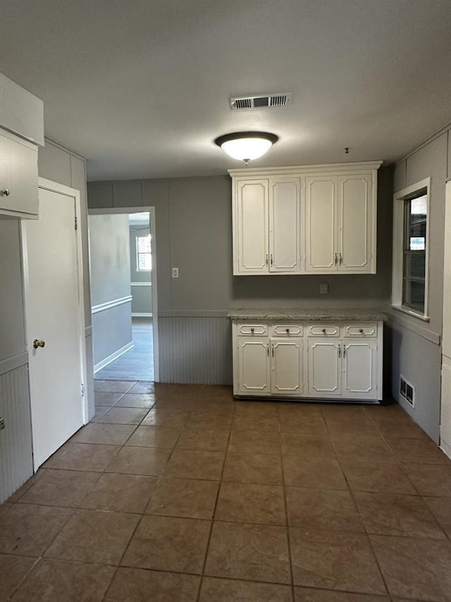 kitchen with dark tile patterned flooring and white cabinetry