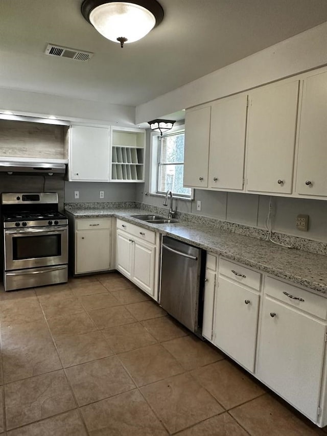 kitchen with stainless steel appliances, tile patterned flooring, white cabinetry, and sink