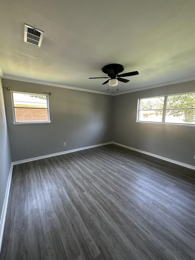 empty room with ceiling fan, ornamental molding, dark hardwood / wood-style flooring, and plenty of natural light