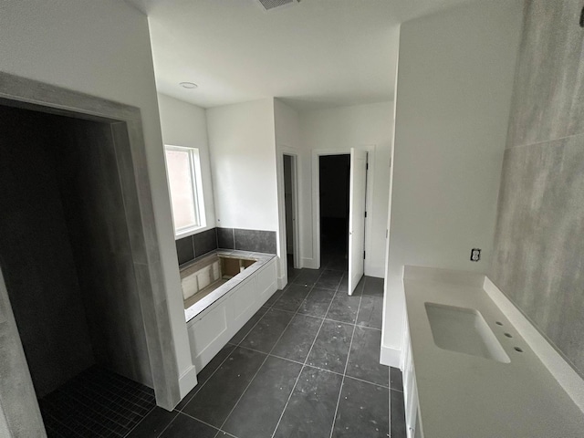 bathroom featuring tile patterned floors, vanity, and a tub