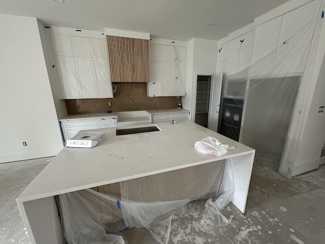 kitchen with white cabinets, a kitchen island, and sink