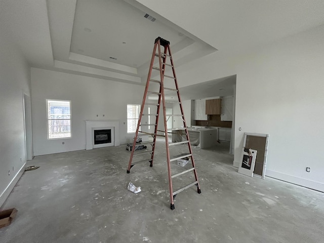 unfurnished living room featuring a tray ceiling