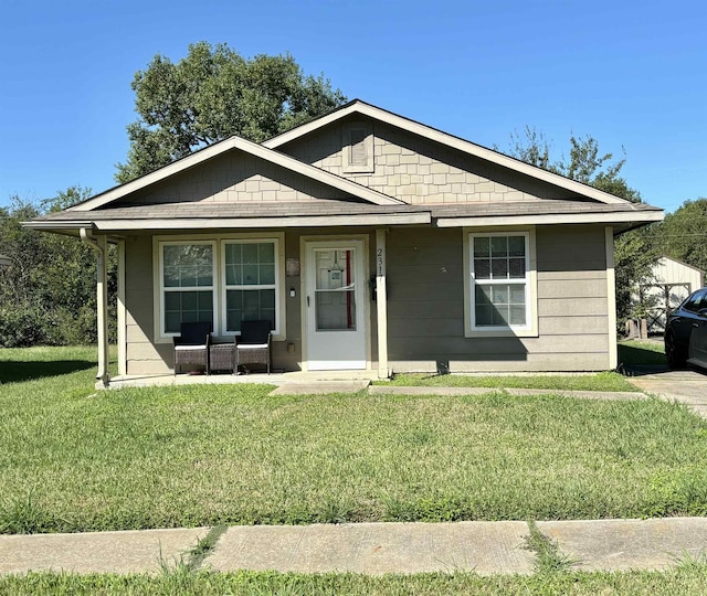 bungalow-style house featuring covered porch and a front yard