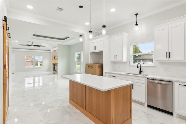 kitchen with dishwasher, sink, ceiling fan, a kitchen island, and white cabinetry